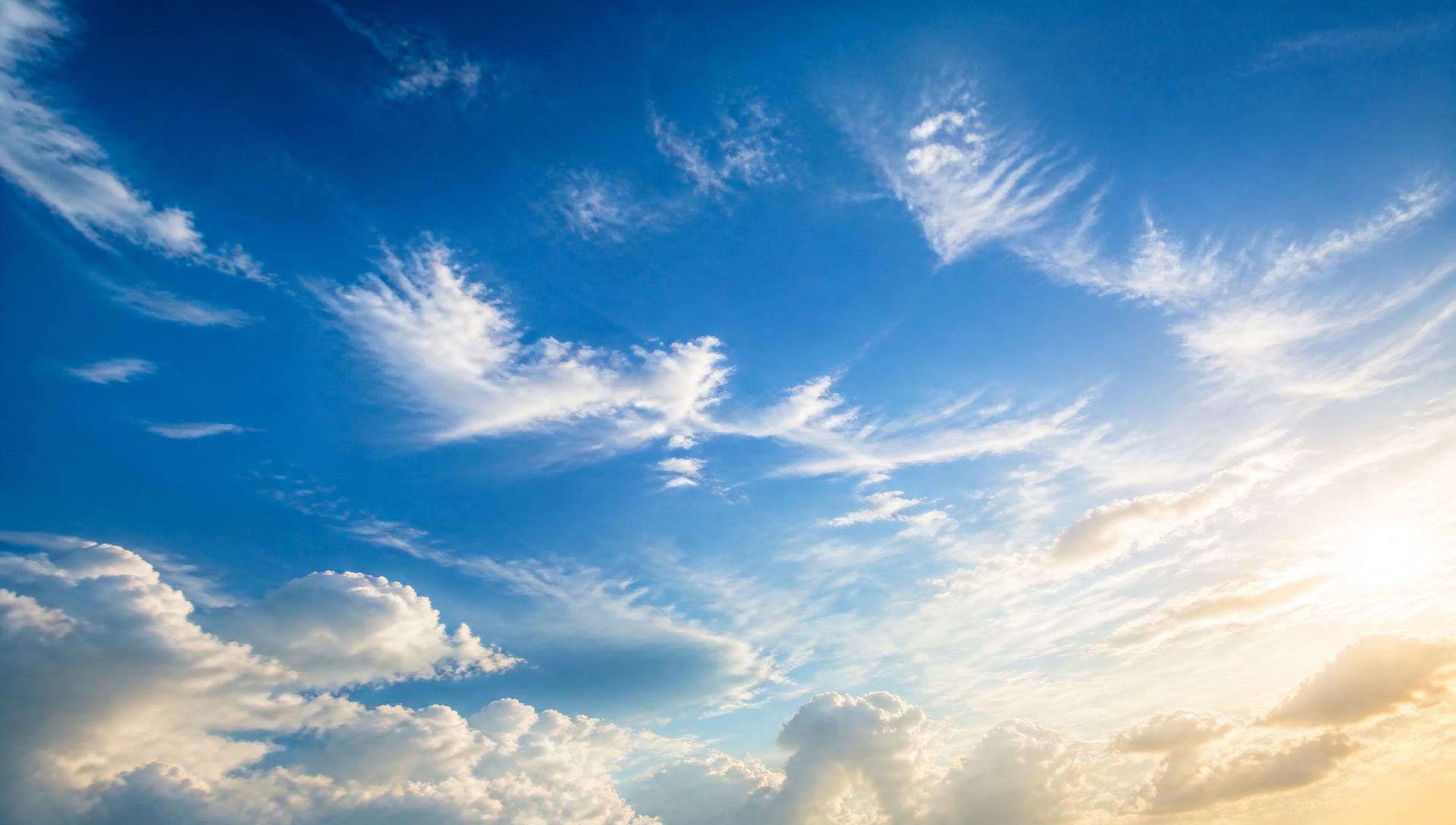 Open bright blue sky with sunlit clouds